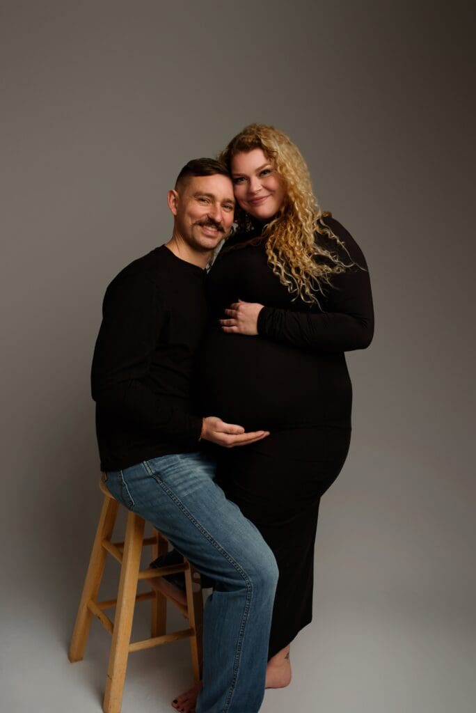 a husband and wife poses for their Columbus Ohio Maternity photographer