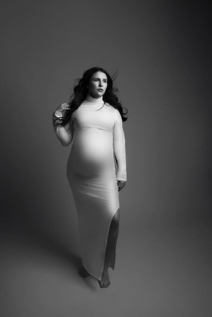 in studio session with white dress on and gray background maternity central ohio