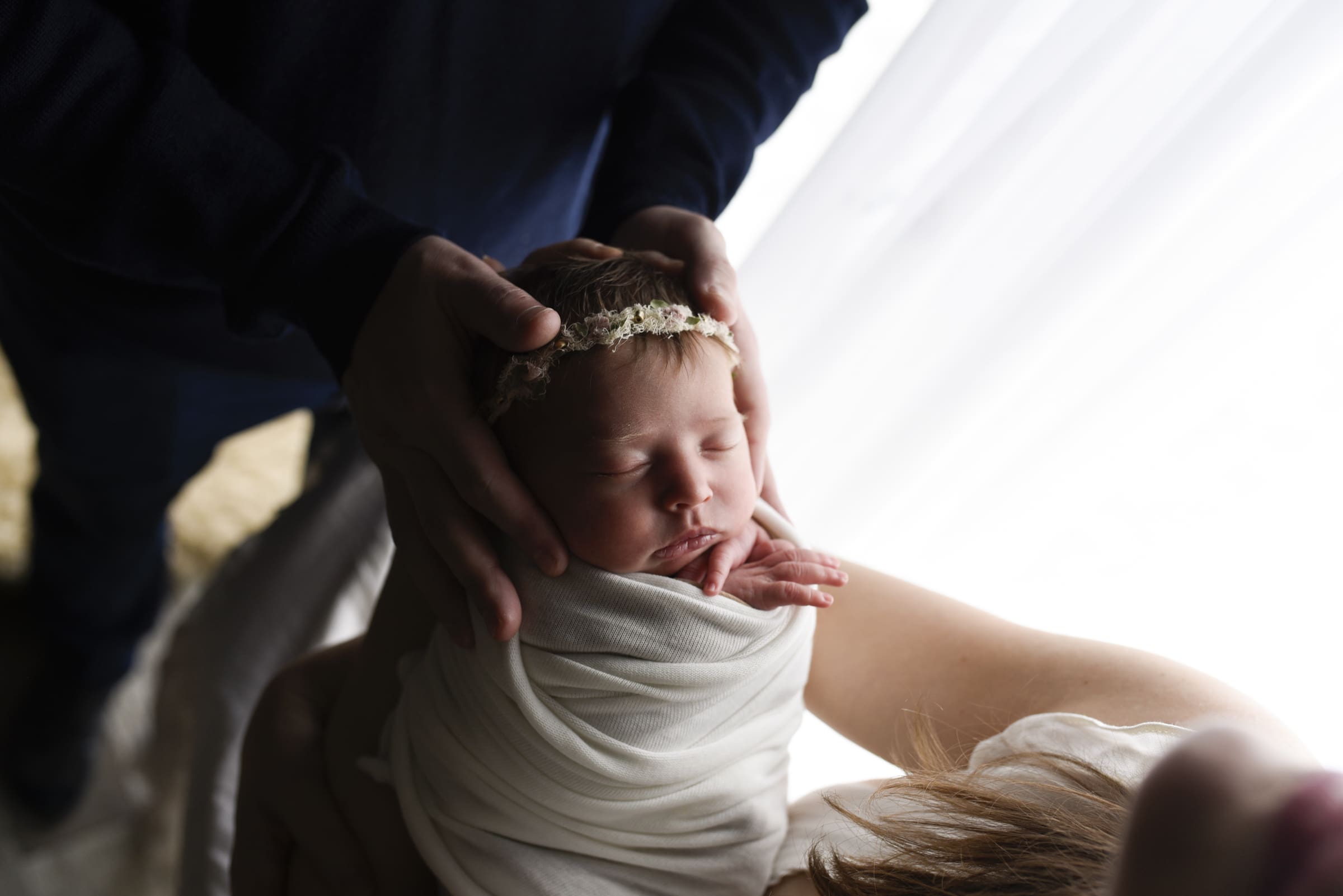 columbus newborn photographer whispyshadesphotography 60 mom and dad holding baby's head in hand and you can only see mom and dads hands and babys face
