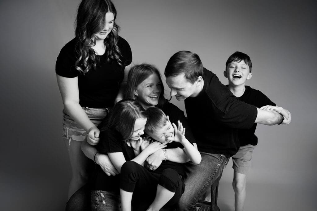 columbus ohio family photographer black and white family portrait of mom and dad surrounded by kids giggling together