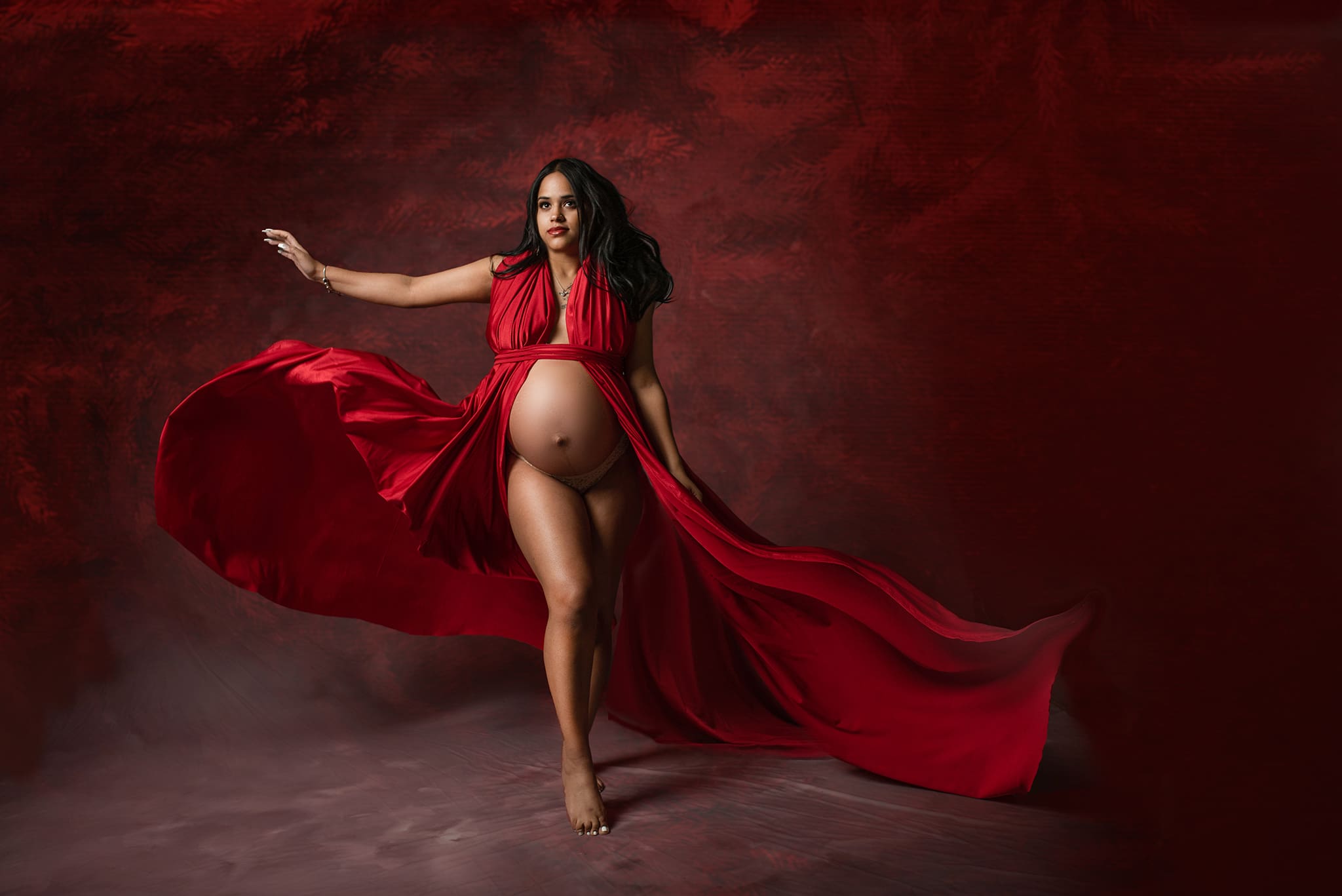 central ohio maternity photographer fashion maternity shoot with mother wearing red dress having it flare out the the sides