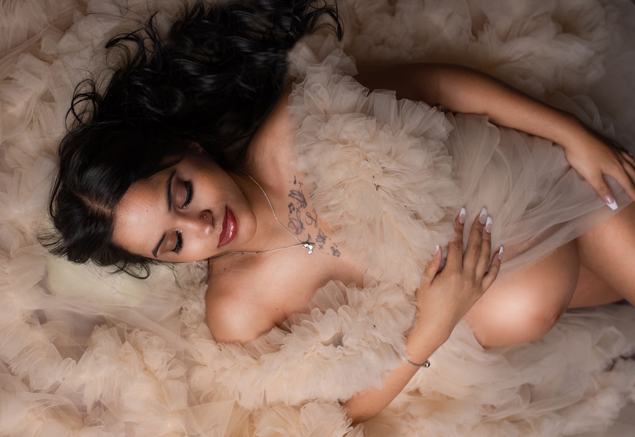 columbus ohio maternity photographer 16 pregnant mom laying down holding her belly wearing a ivory dress with eyes closed